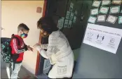  ?? ARIC CRABB — STAFF PHOTOGRAPH­ER ?? First grade instructor Erin Salcido, right, has a student sanitize his hands before entering her classroom on Thursday at Alisal Elementary School in Pleasanton. Students returned to for hybrid in-person classes.