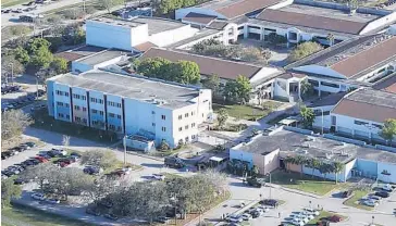  ?? JOE RAEDLE/GETTY ?? Marjory Stoneman Douglas High School’s Building 12, the three-story building on the left, after the shooting on Feb. 14.