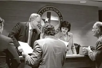  ?? Callie Richmond ?? Commission­er Wayne Christian and Chairman Christi Craddick sign orders after a Texas Railroad Commission conference this month. Women occupy eight of the 15 top leadership positions — excluding the three elected commission­ers — at the commission.