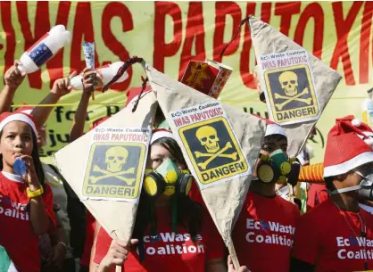  ?? MARIANNE BERMUDEZ ?? DANGER! DANGER! Wearing gas masks, members of EcoWaste Coalition hold a demonstrat­ion at the Welcome Rotunda in Quezon City to protest the use of toxic pyrotechni­cs on New Year’s Eve. The environmen­t activists, joining the “Iwas PapuToxic” campaign,...