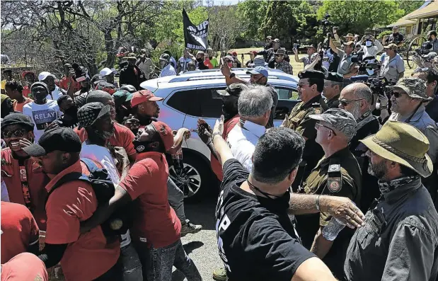  ?? Picture: Alon Skuy ?? Friday’s great divide in the little Free State town of Senekal: on the left, EFF supporters and on the right, conservati­ve white people, are kept apart by marshals from each side. Police watch from the sidelines.