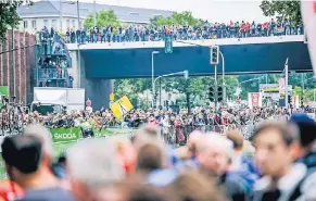  ?? RP-FOTO: ANDREAS BRETZ ?? Am ersten Tag kamen wegen des schlechten Wetters weniger Zuschauer als erwartet, dennoch war es an vielen Stellen der Strecke (hier: Oberkassel­er Brücke) voll.