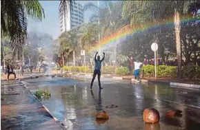  ?? EPA PIC ?? A protester gesturing towards police water cannons outside the Zimbabwe Electoral Commission in Harare, Zimbabwe, on Wednesday.