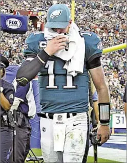  ??  ?? Carson Wentz covers his face with a towel and limps off field with a knee injury that doctors fear could be a season-ending ACL tear, which would cripple Eagles’ Super Bowl aspiration­s.