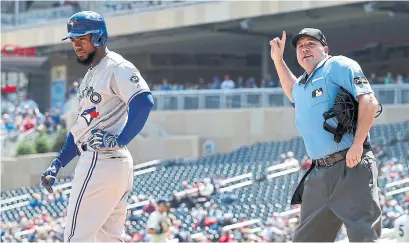  ?? JIM MONE/THE ASSOCIATED PRESS ?? Jays outfielder Teoscar Hernandez is headed to the dugout after striking out in the third inning and manager John Gibbons, as umpire Dan Bellino is indicating, is headed to the clubhouse for disputing the call — his first ejection of the season.