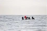  ?? (AFP) ?? This file photo shows migrants on a boat hidden in waves in agitated waters between Sangatte and Cap Blanc-Nez, in the English Channel