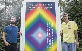  ?? ALYSSA POINTER / ALYSSA.POINTER@AJC.COM ?? Visual artist Matthew Terrell (left) and fabricator George Faughnan show off their latest project, “The Hate Shield,” at a home in Atlanta this week. Terrell said he’d like to refine the panels to make them more soundproof and lightweigh­t.