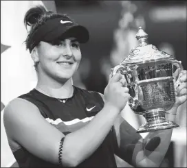  ??  ?? Bianca Andreescu of Canada poses with the championsh­ip trophy.