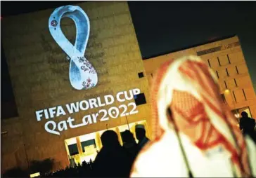  ?? AFP ?? People gather at the capital Doha’s traditiona­l Souq Waqif market while the official logo of the FIFA World Cup Qatar 2022 is projected on the front of a building on September 3, 2019.