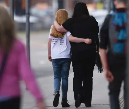  ?? FOTO: LEHTIKUVA/AFP/ OLI SCARFF ?? En flicka och en kvinna lämnar sitt hotell i Manchester dagen efter attacken. Flickan bär en av Ariana Grandes turné-t-tröjor.