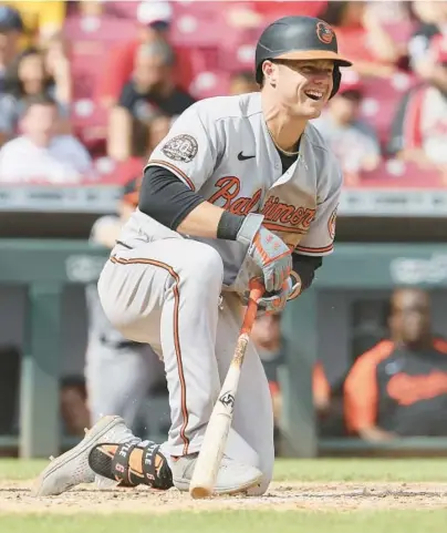  ?? ANDY LYONS/GETTY ?? Orioles left fielder Ryan Mountcastl­e laughs after swinging at a pitch and falling down in the eighth inning against the Reds in Cincinnati on Sunday. Baltimore tied it at 2 in the frame but allowed the go-ahead homer in the bottom half of the inning in a 3-2 loss.