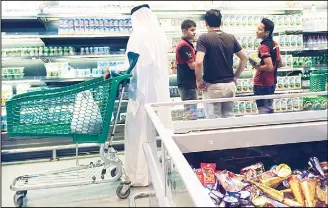  ?? (AFP) ?? In this file photo, customers are seen shopping at the al-Meera market in the Qatar capital Doha. Qatar has weathered the economic impacts of a stifling Saudi-led blockade, maintainin­g healthy growth, but some sectors continue
to pay the price a year...