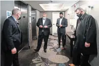  ?? NATHAN DENETTE THE CANADIAN PRESS ?? Premier Doug Ford waits for an elevator with his staff and security as he visits the Holiday Inn in Oshawa, which is being used as a COVID-19 isolation hotel.