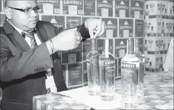  ?? (GRA photo) ?? A customs officer demonstrat­ing how the stamp is affixed