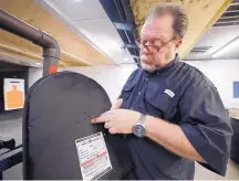  ?? MICHAEL WYKE /ASSOCIATED PRESS ?? Steve Naremore, founder and CEO of TuffyPacks, shows the impact points on a ballistic shield retrieved from a backpack after a shooting demonstrat­ion of the product’s stopping ability Friday.