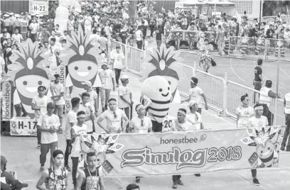  ??  ?? Honestbee mascot and higantes at the Sinulog Grand Parade.