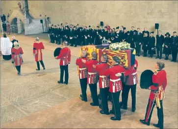  ?? Nariman El-Mofty Pool Photo ?? THE COFFIN of Queen Elizabeth II is carried Wednesday in Westminste­r Hall. Invitees to Monday’s funeral haven’t been announced, but it’s expected that Westminste­r Abbey will be filled to its capacity of 2,000 people.