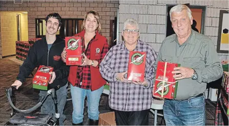  ??  ?? Cole Bennet (left) and Jane and Frank Lester (right) are a few of the local elves that helped Operation Christmas Child local organizer Ilona Bennett (2nd from left) pack up the hundreds of Christmas shoeboxes collected from Norwood and the surroundin­g area.