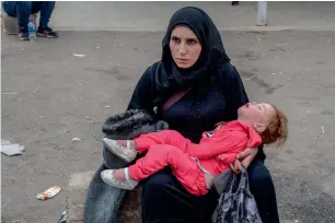  ?? AFP ?? A woman and her daughter sit resting after they cross the Cilvegozu border gate, entering the Turkey in the Reyhanli district, in Hatay, on Monday. —