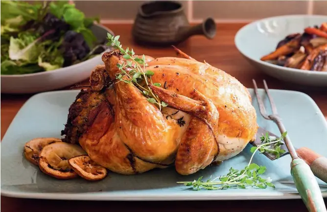  ?? PHOTOS: NICOLA GALLOWAY ?? If you can’t be bothered fussing over turkey, or are not a big fan of it, this tender roast chicken with herb and lemon stuffing makes a tasty substitute.