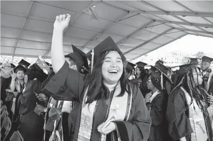  ?? BARBARA HADDOCK TAYLOR/BALTIMORE SUN PHOTOS ?? Juana Alfaro Bonilla, of Silver Spring, waves to her family at the Morgan State University commenceme­nt ceremony Saturday.