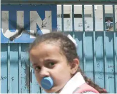  ?? — AFP ?? A Palestinia­n girl is seen outside a school run by the United Nations Relief and Works Agency’s in the Askar refugee camp east of Nablus in the occupied West Bank on Monday.