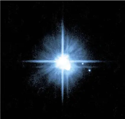  ??  ?? EN ESTA imagen captada por el Telescopio Espacial Hubble, Plutón luce brillante al centro, rodeado por las lunas Caronte (justo debajo de él), Nix e Hydra (ambas a la derecha).