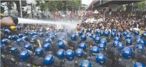  ??  ?? (TOP) PROTESTERS burn an effigy of US President Donald J. Trump; (BOTTOM) Police hose down protesters as they try to march to the venue of the Associatio­n of Southeast Asian Nations (ASEAN) Summit in Manila on Nov. 13, where US President Donald J....