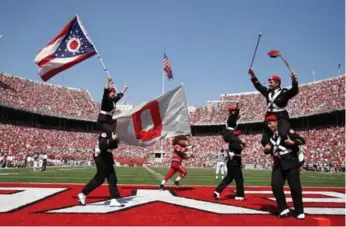  ?? J. KEVIN FITZSIMONS/OHIO STATE UNIVERSITY ?? Buckeye marching band members celebrate a touchdown at the nearly 105,000-seat Ohio Stadium.