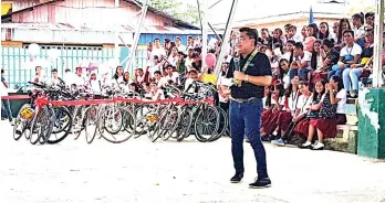  ??  ?? EMPATHIZIN­G. Undersecre­tary Umali delivering his speech and recalling his high school years when he too had to walk to school.