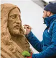  ?? Foto: Jens Büttner, dpa ?? Hier arbeitet ein Sandkünstl­er an einer Christusfi­gur.