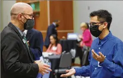  ?? ?? Georgia Gwinnett College student Brian Catalan (right) chats with Justin Jernigan Sr., associate vice president of the school. Catalan said he wanted to take full advantage of the event to look for career opportunit­ies right for him.