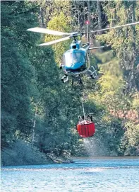  ?? Photograph by Mike Sutherland ?? A helicopter was brought in to water bomb the area.