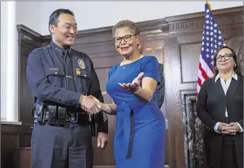  ?? Gina Ferazzi Los Angeles Times ?? DOMINIC CHOI, left, shakes hands with Mayor Karen Bass after being named interim LAPD chief on Feb. 7 at City Hall. The city has hired a headhuntin­g firm to come up with a list of candidates to lead the department.
