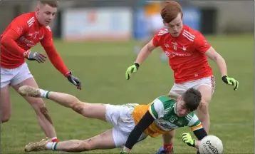  ??  ?? Aaron Kellaghan of Offaly loses out to Louth’s Ciaran Keenan.