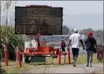  ?? JANE TYSKA — STAFF PHOTOGRAPH­ER ?? People walk past a social distancing awareness sign along Shore Line Drive near Crown Beach in Alameda on Wednesday.