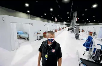  ?? AP ?? Mark Sexton, deputy director of the Georgia Emergency Management and Homeland Security Agency, tours a hospital facility the state is reactivati­ng at a convention centre in Atlanta as coronaviru­s infections in the United States continue to increase.