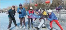  ?? WANG WANTING / CHINA DAILY ?? Locals pose on the frozen Shichahai Lake, used as an ice rink in winter.