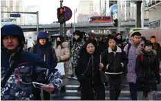  ?? GREG BAKER/AFP/GETTY IMAGES ?? Commuters walk in Beijing’s central business district. A new survey finds Canadian CEOs are less interested in China and the U.S. as key markets for growth.