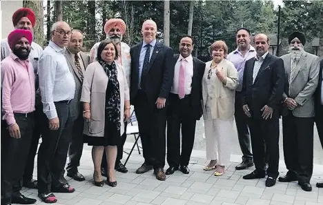  ??  ?? Premier John Horgan, centre, and Surrey Mayor Linda Hepner, fourth from right, pose with others at a private function, including convicted gunman Maninder Gill, fourth from left. MLA Jinny Sims is fifth from left.
