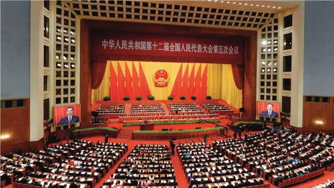  ?? —AFP ?? BEIJING: A general view shows the opening session of the National People’s Congress, China’s legislatur­e, in Beijing’s Great Hall of the People yesterday. China’s top economic official trimmed the country’s growth target and warned yesterday of dangers...