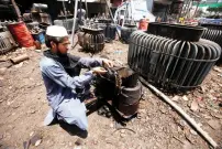  ??  ?? An employee repairs an electricit­y transforme­r at a workshop in Peshawar. (Reuters)