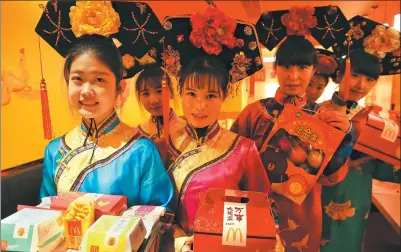  ?? JIANG DONG / CHINA DAILY ?? Waitresses in Qing Dynasty (1644-1911) costumes serve fast food at a McDonald’s restaurant in Beijing.