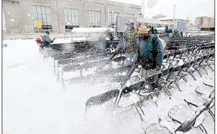  ?? AP/ROGELIO V. SOLIS ?? Workers clear rare heavy snow Friday in Jackson, Miss., from chairs set up for today’s dedication of the Museum of Mississipp­i History and the Mississipp­i Civil Rights Museum. Many in the state’s black community, despite waiting decades for a...