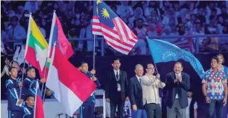  ?? BBXPIX ?? Philippine Secretary of Foreign Affairs and chairman of the SEA Games 2019 Organising Committee Alan Peter S. Cayetano holding the SEA Games Federation flag after receiving it from federation president Tunku Tan Sri Imran Tuanku Jaafar (second from...