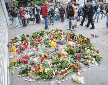  ?? FOTO: DPA ?? Blumen und Kerzen liegen vor dem Supermarkt, in dem am Freitag ein Mann einen Menschen mit einem Messer getötet und sechs weitere verletzt hat. Der Täter, ein Islamist, war den Verfassung­sschützern bekannt.