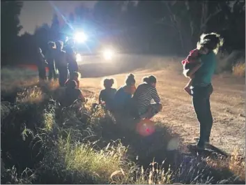  ?? John Moore Getty Images ?? BORDER PATROL agents arrive to detain Central American asylum seekers near the U.S.-Mexico border in McAllen, Texas, which is home to a sprawling facility that processes immigrants crossing illegally.