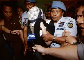  ?? REUTERS ?? CONVICTED Australian drug trafficker Schapelle Corby is escorted by police from the prosecutor’s office in Denpasar, following her release from Kerobokan Prison.