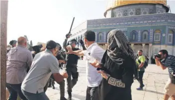  ??  ?? Un policía israelí reprime a palestinos afuera del Domo de la Roca.