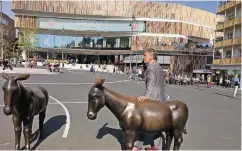  ??  ?? Wolfgang Rolshoven beim Besuch in Gladbach – die Esel gehören zu einem Werk von Rita McBride. Im Hintergrun­d: das Einkaufsze­ntrum Minto.